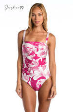 Model is wearing a fuchsia and white multicolored tropical printed bandeau one piece from our Sunshine 79 brand.