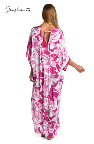 Model is wearing a fuchsia and white multicolored tropical printed maxi dress cover up from our Sunshine 79 brand.