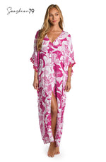 Model is wearing a fuchsia and white multicolored tropical printed maxi dress cover up from our Sunshine 79 brand.