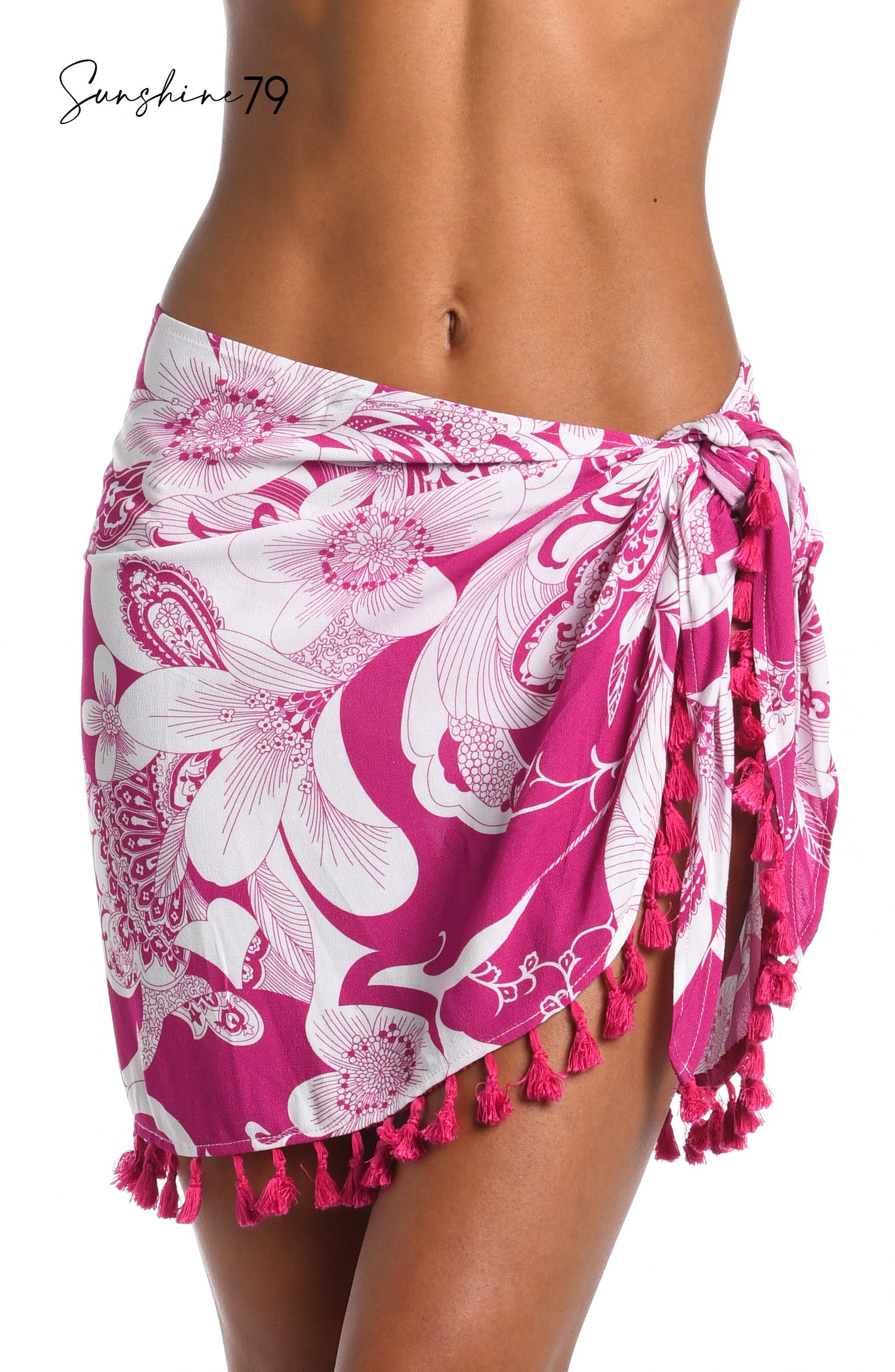 Model is wearing a fuchsia and white multicolored tropical printed short pareo wrap cover up from our Sunshine 79 brand.
