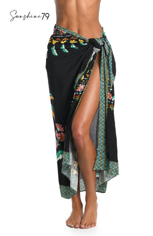 Model is wearing a black multicolored palm tree printed pareo wrap cover up from our Sunshine 79 brand.