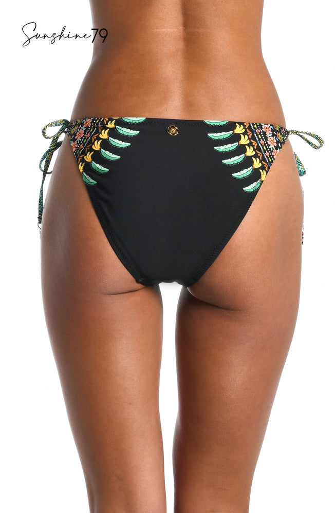 
            
                Load image into Gallery viewer, Model is wearing a black multicolored palm tree printed tie side hipster bikini bottom from our Sunshine 79 brand.
            
        
