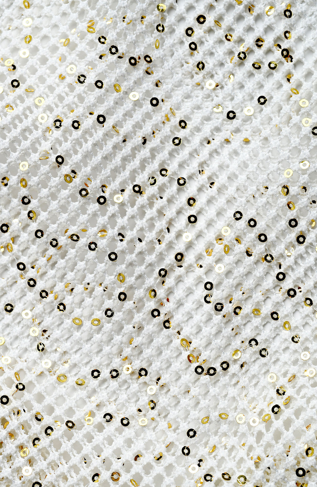 Pattern of gold and black sequins on a textured white background