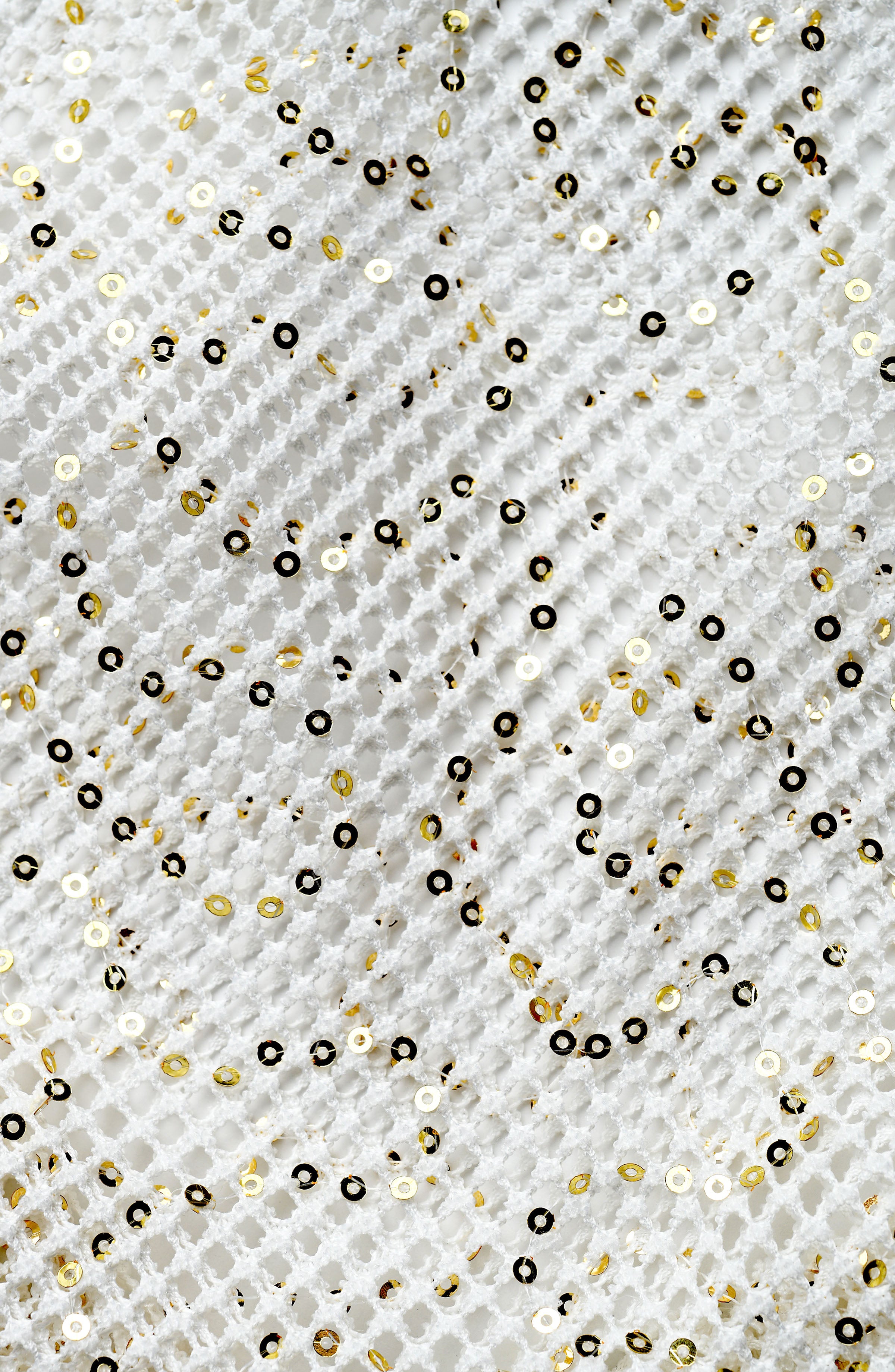 Pattern of gold and black sequins on a textured white background