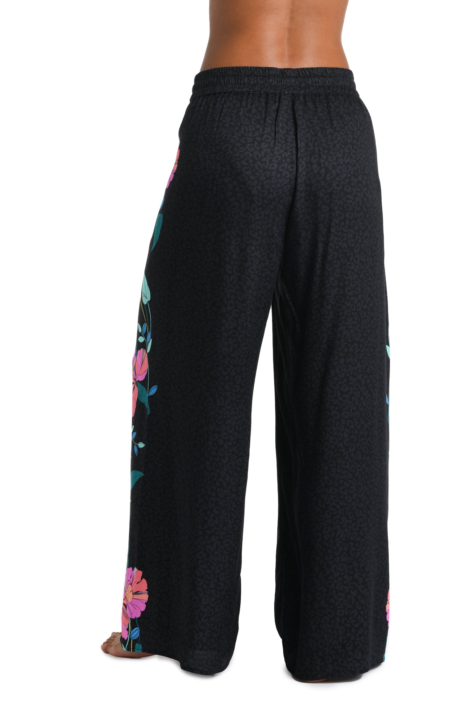 Model is wearing a black, pink, and green multicolored floral patterned Beach Pant