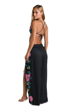 Model is wearing a black, pink, and green multicolored floral patterned Beach Pant