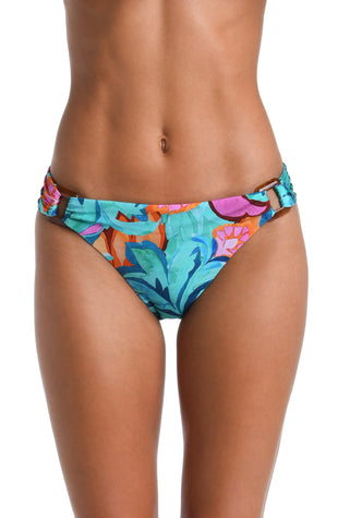 Model is wearing a turquoise, blue, coral multicolored floral printed Side Shirred Hipster Bottom
