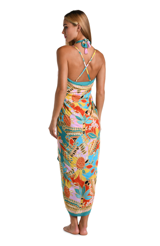 Model is wearing a pink, orange, blue, and yellow multicolored tropical printed Pareo Wrap