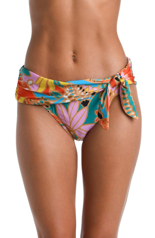 Model is wearing a pink, orange, blue, and yellow multicolored tropical printed Sash Hipster Bottom