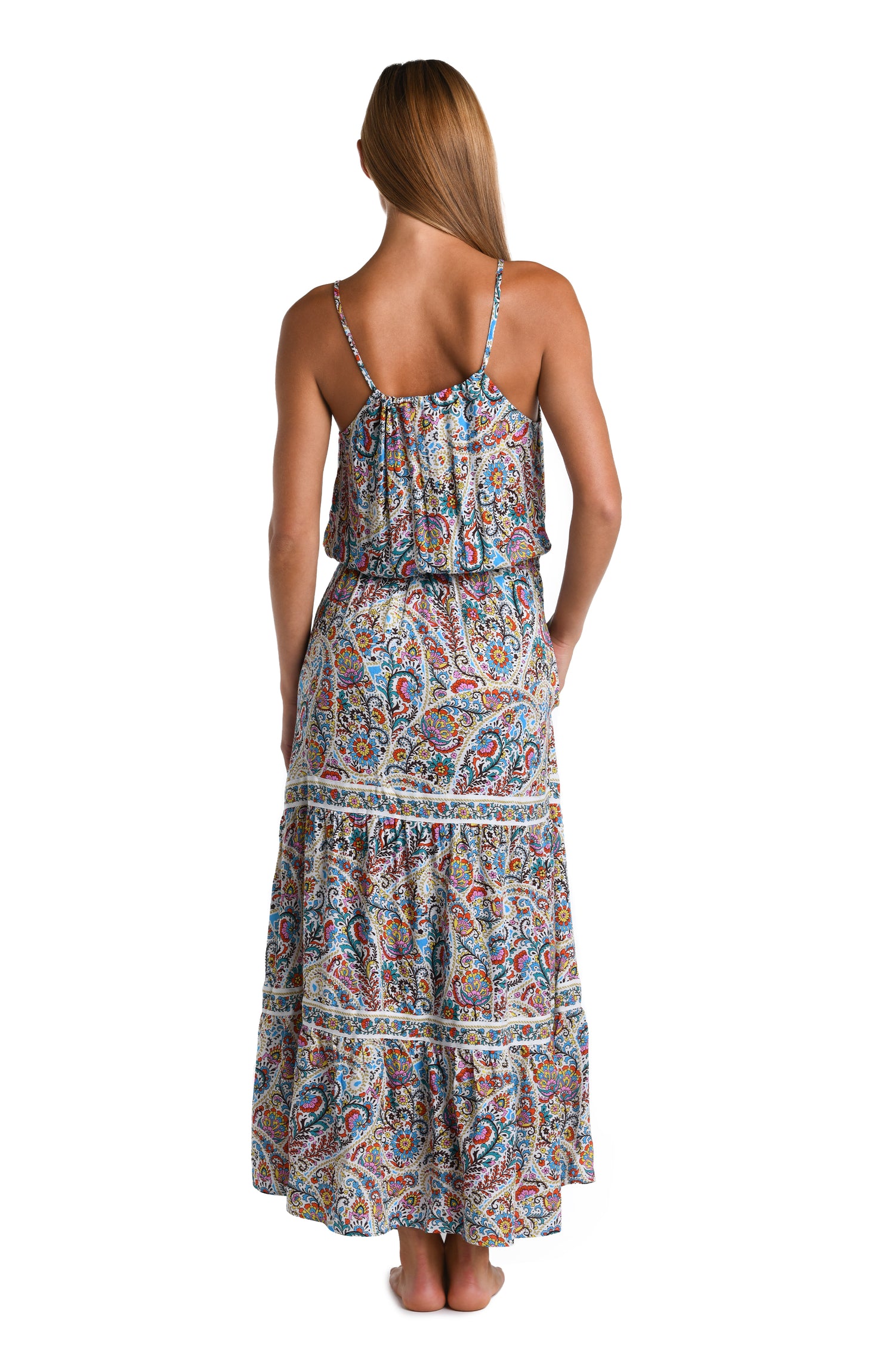 Model is wearing a white, red, blue, green, and yellow multicolored paisley printed Maxi Dress