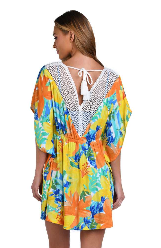 Model is wearing a blue, green, and orange multi colored floral printed tunic swimsuit cover up.