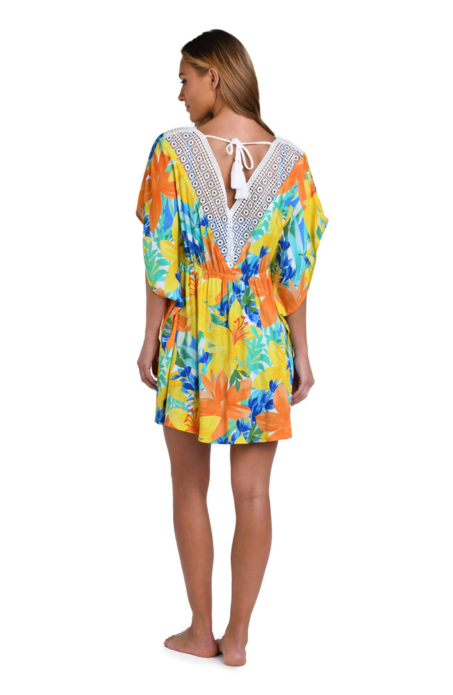 Model is wearing a blue, green, and orange multi colored floral printed tunic swimsuit cover up.