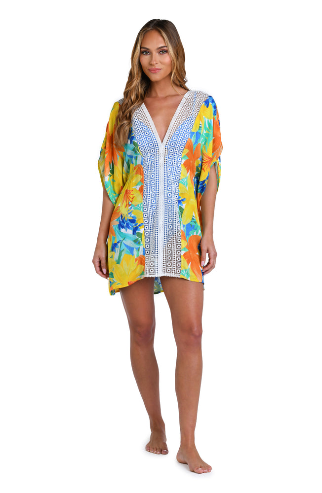 Model is wearing a blue, green, and orange multi colored floral printed tunic swimsuit cover up.