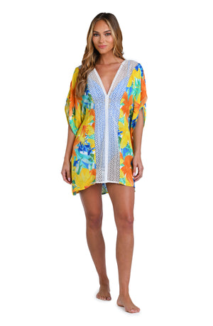 Model is wearing a blue, green, and orange multi colored floral printed tunic swimsuit cover up.