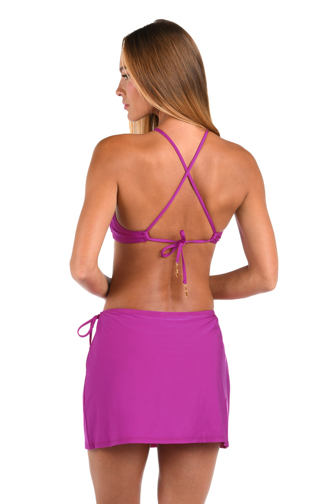 Back image of model wearing a Sunshine 79 Sunshine Solids Wrap Skirt Cover Up in Bright Violet.