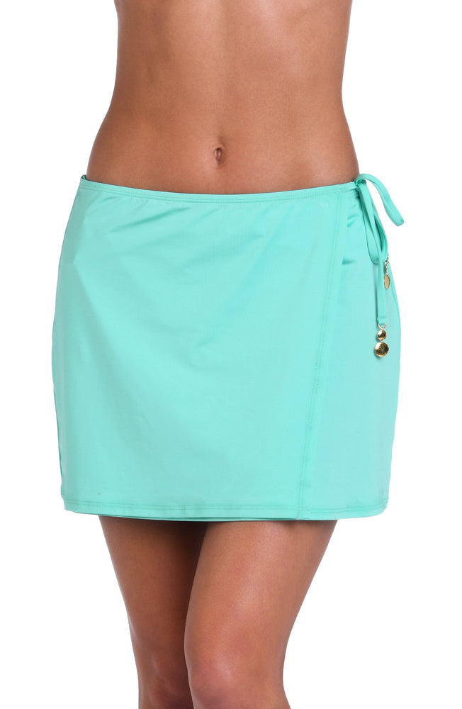 Model is wearing a solid pale, greenish-blue (seaglass) colored mini skirt cover up.