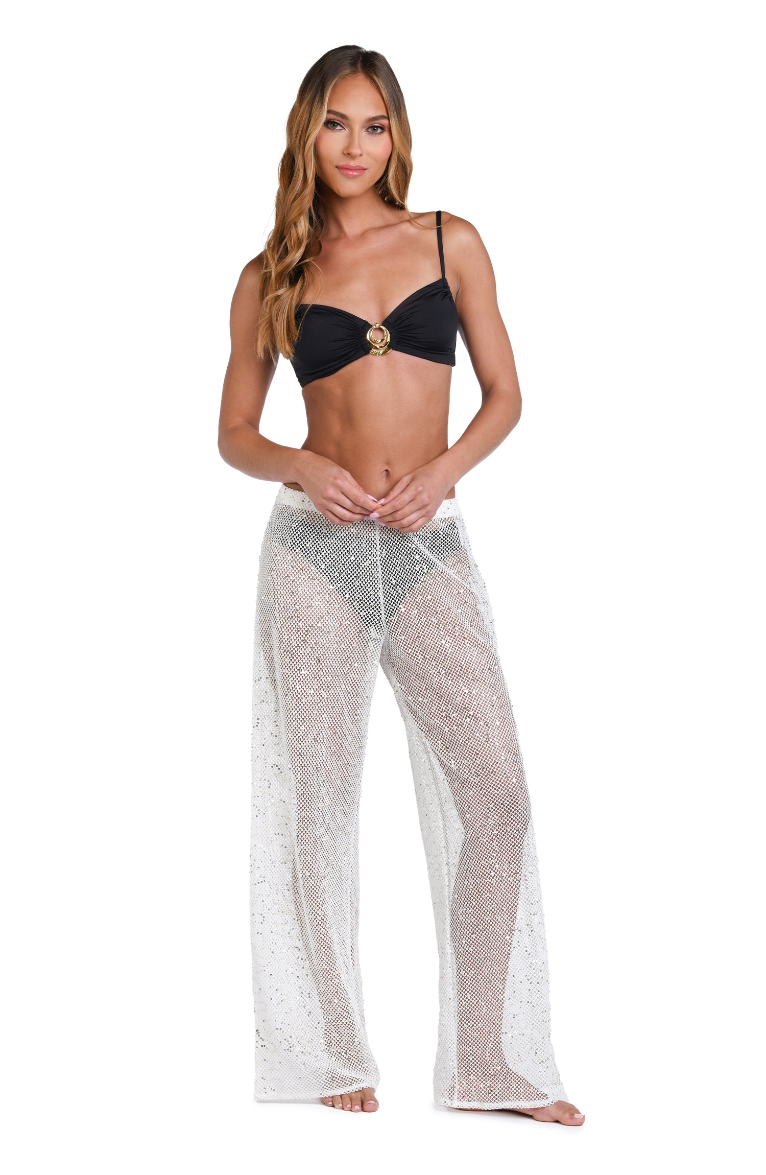 Model is wearing a white colored sheer beach pant cover up.