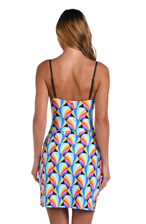 Model is wearing a pink, blue, yellow, and orange multicolored short pareo wrap cover up on a geometric patterned black background.