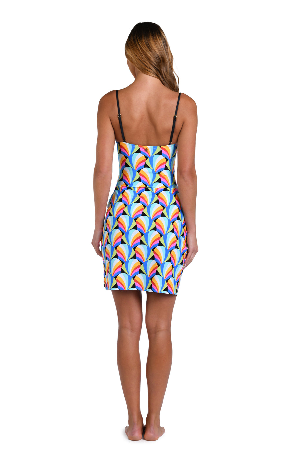 Model is wearing a pink, blue, yellow, and orange multicolored short pareo wrap cover up on a geometric patterned black background.