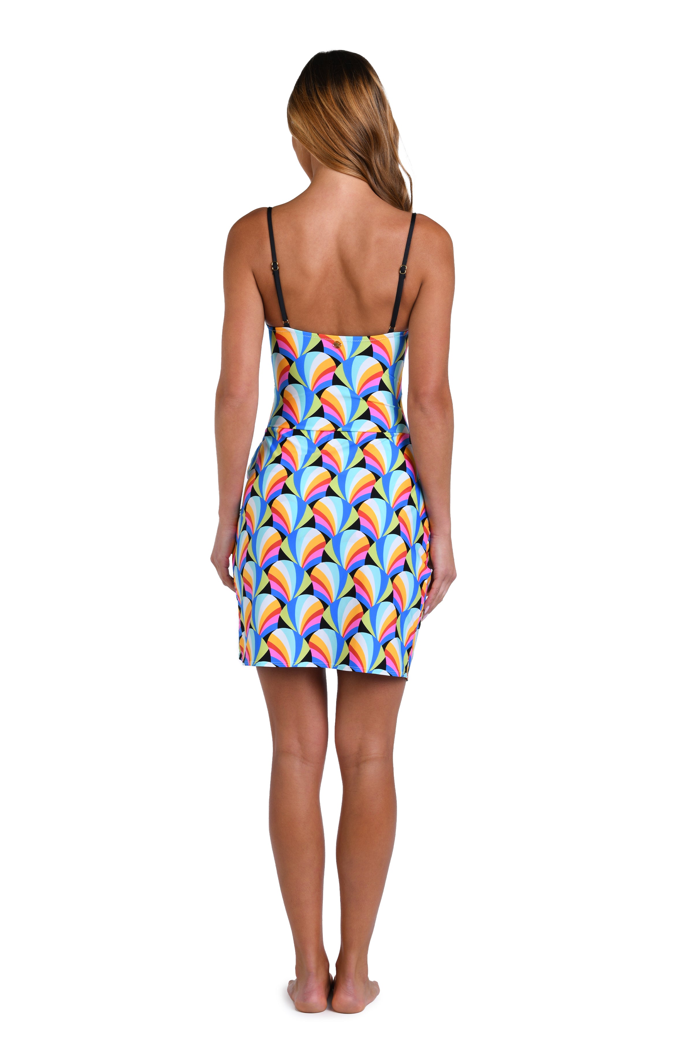 Model is wearing a pink, blue, yellow, and orange multicolored short pareo wrap cover up on a geometric patterned black background.