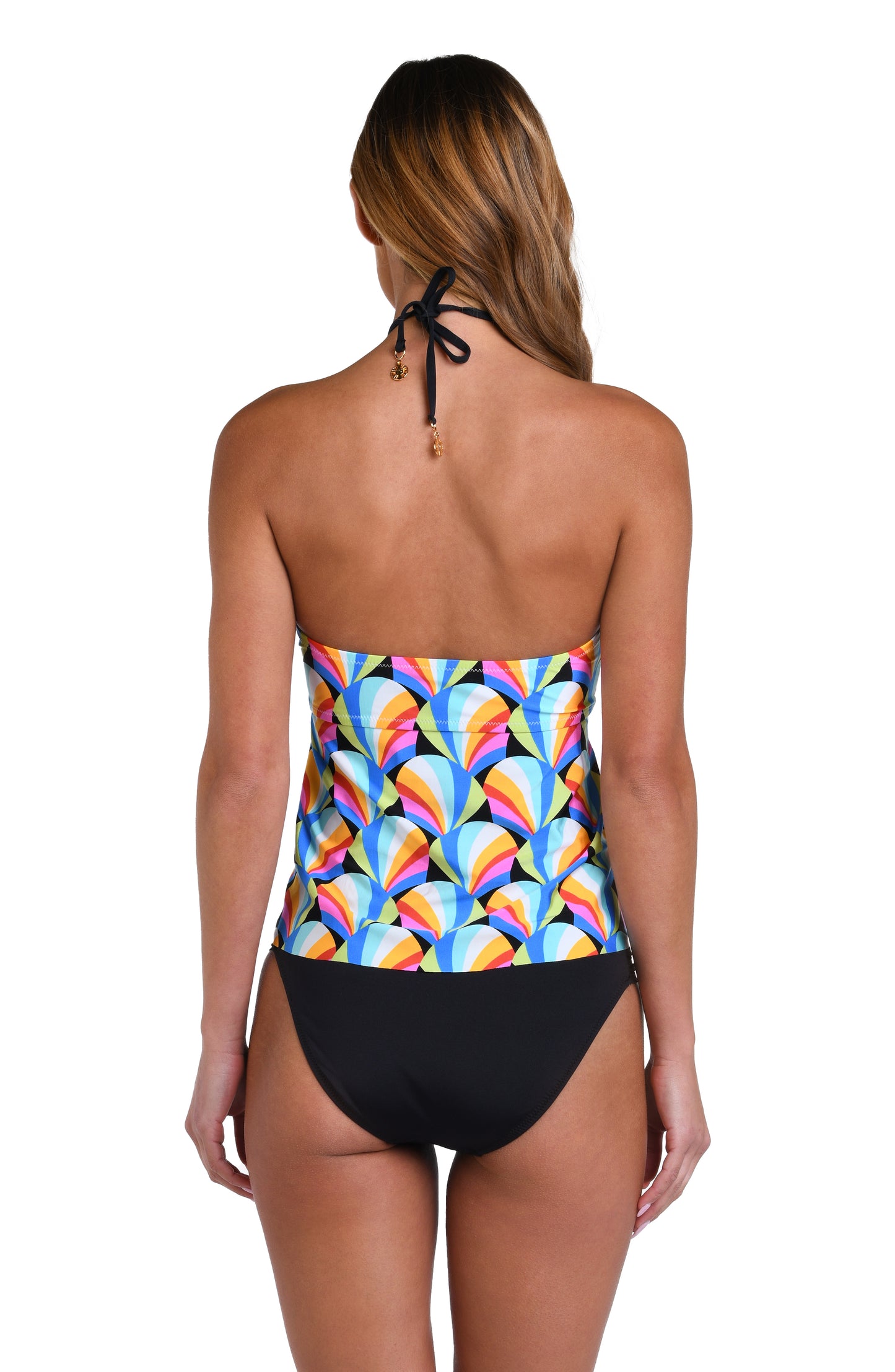 Model is wearing a pink, blue, yellow, and orange multicolored bandeau tankini top on a geometric patterned black background.