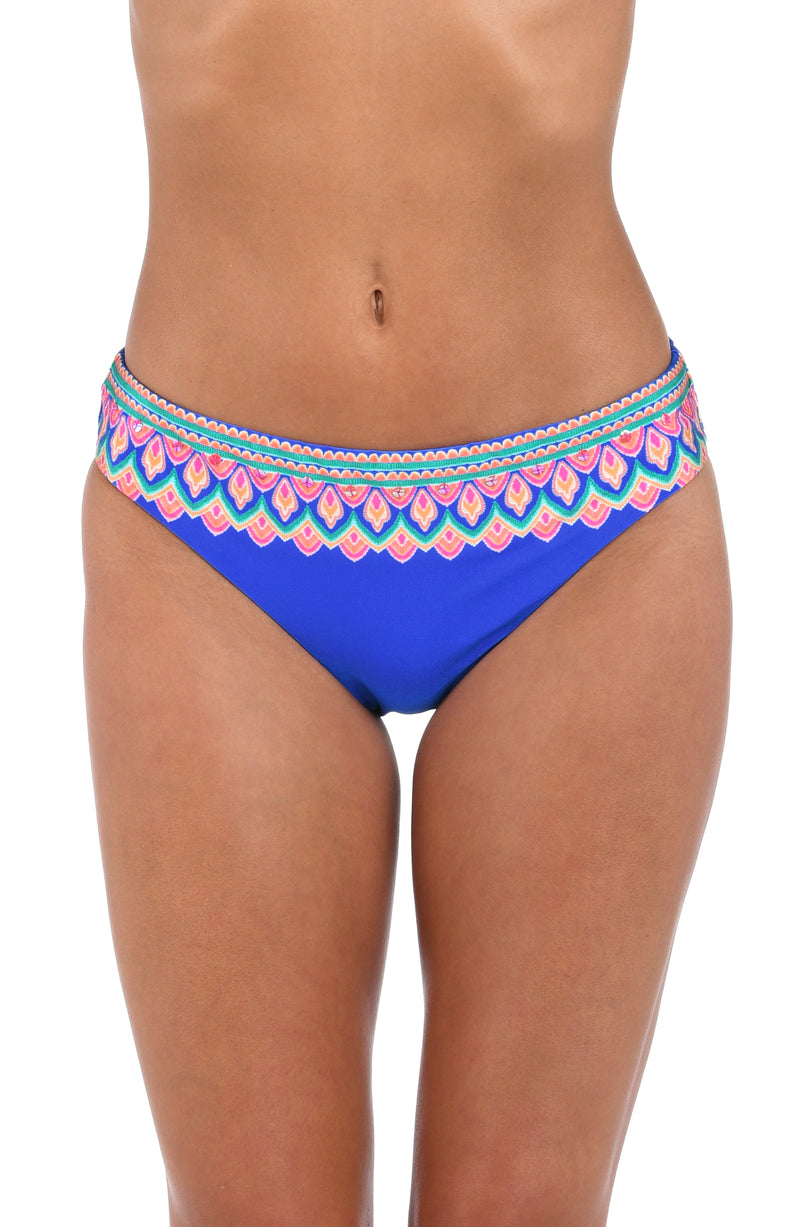 Front image of model wearing the Jewel Essence Hipster Bottom in an indigo multi colored geometric print.