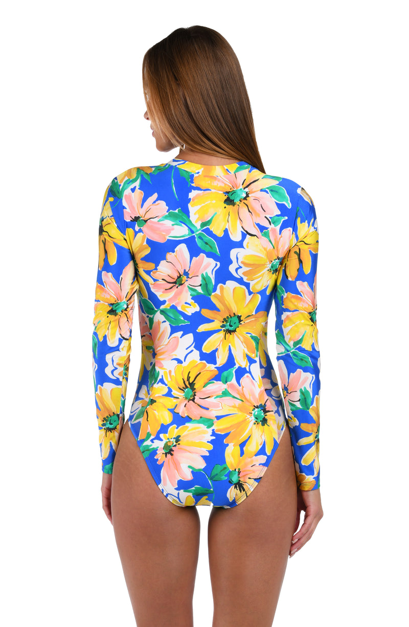 Back image of model wearing the Sunflower Getaway Paddlesuit One Piece in a multi colored tropical print.