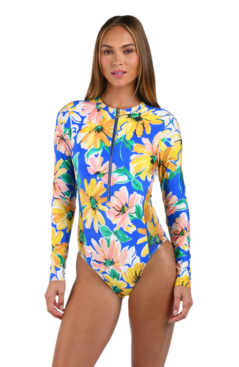 Front image of model wearing the Sunflower Getaway Paddlesuit One Piece in a multi colored tropical print.