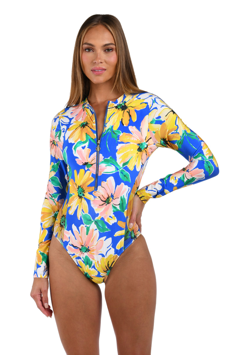 Front image of model wearing the Sunflower Getaway Paddlesuit One Piece in a multi colored tropical print.