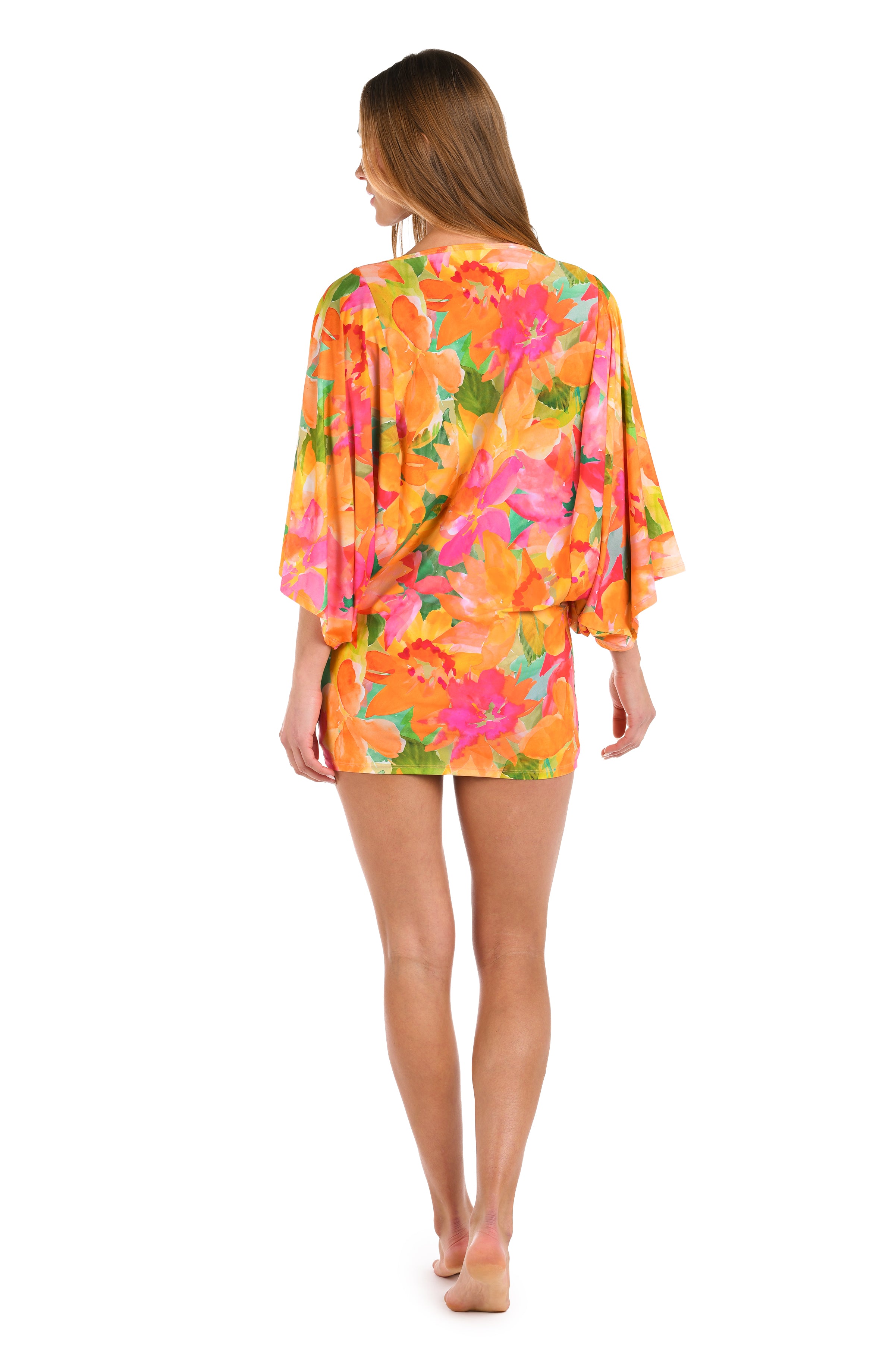 Full body back image of model wearing a scoop neck tunic cover up, with a vibrant, multicolor floral print featuring a straight silhouette and butterfly sleeves.