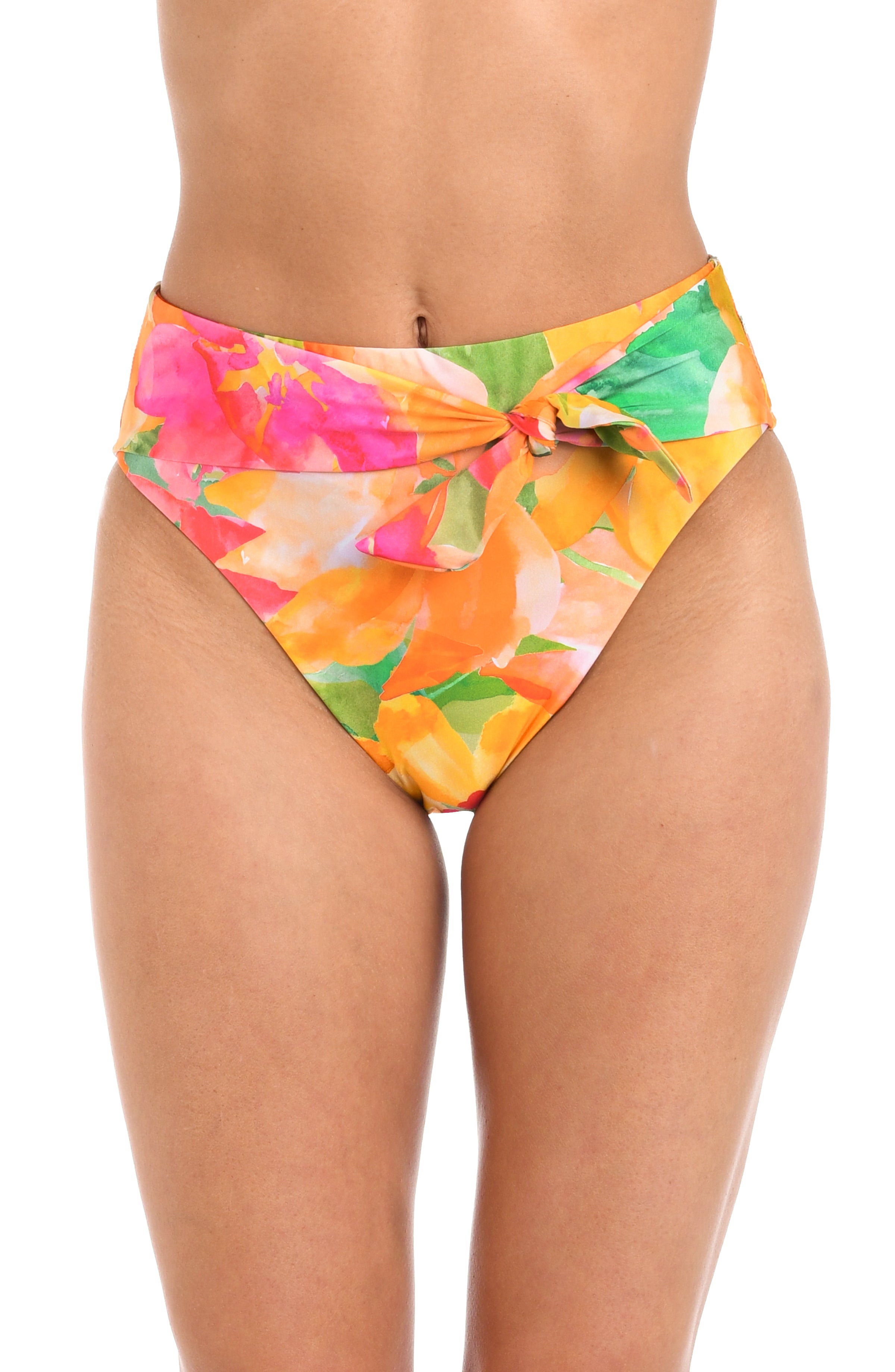 Close up front view of model wearing a high waisted bikini swimsuit bottom  showcasing a multicolored floral print and adjustable sash tie. 