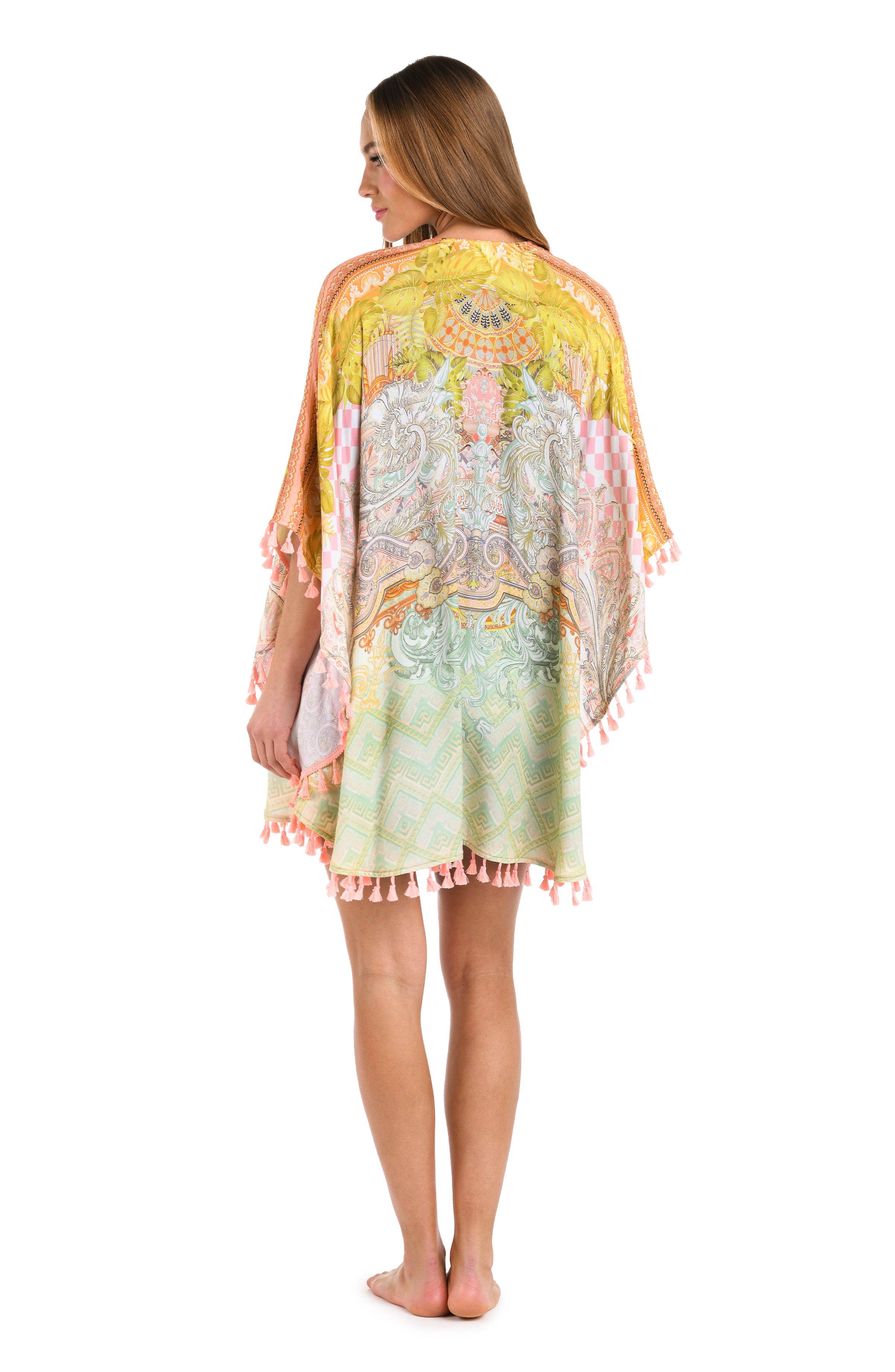 Full body back image of model wearing a multi-colored yellow and orange patterned kimono cover up trimmed with tassels.