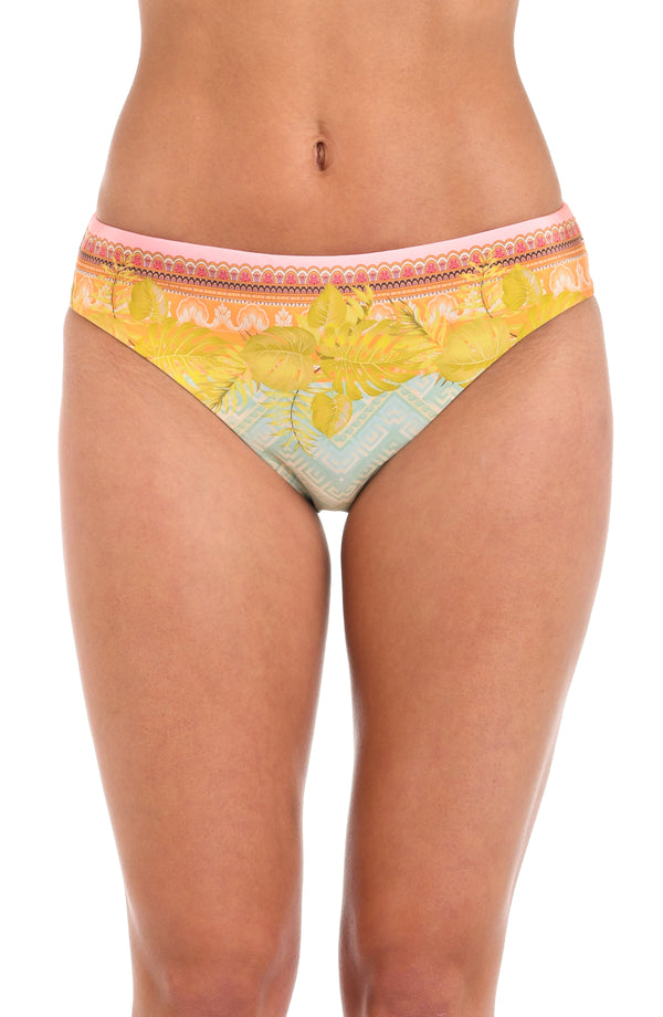 Front image of model wearing a multi-colored pastel yellow, green, and peach patterned hipster bikini swimsuit bottom.