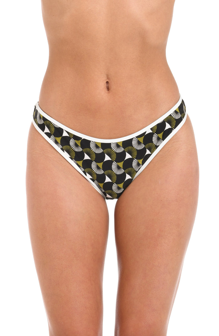 Front image of model wearing a reversible French cut bikini bottom: one side features a solid olive green color with white trim, while the other side showcases a bold black and white geometric print. 