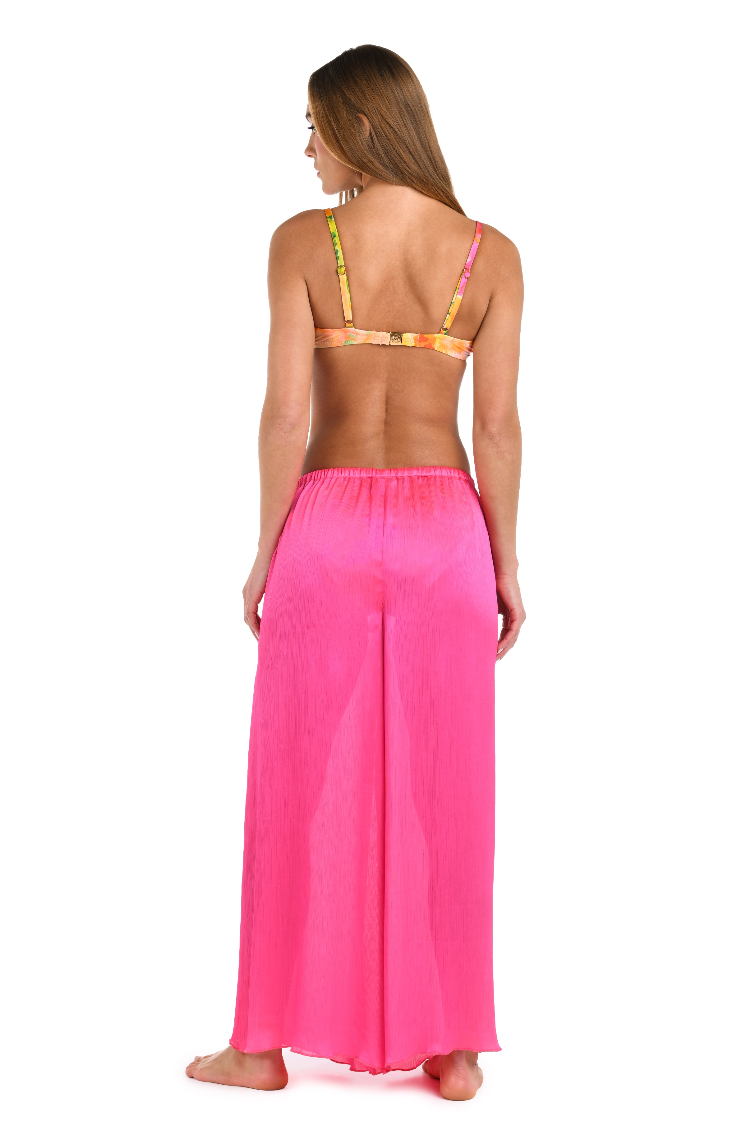 Full back body image of model wearing a solid bright pink crinkle pant cover up.       