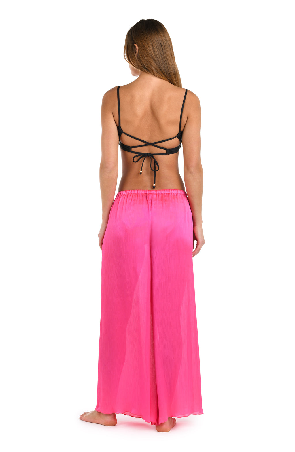 Full body back image of model wearing a solid bright pink crinkle pant cover up.       