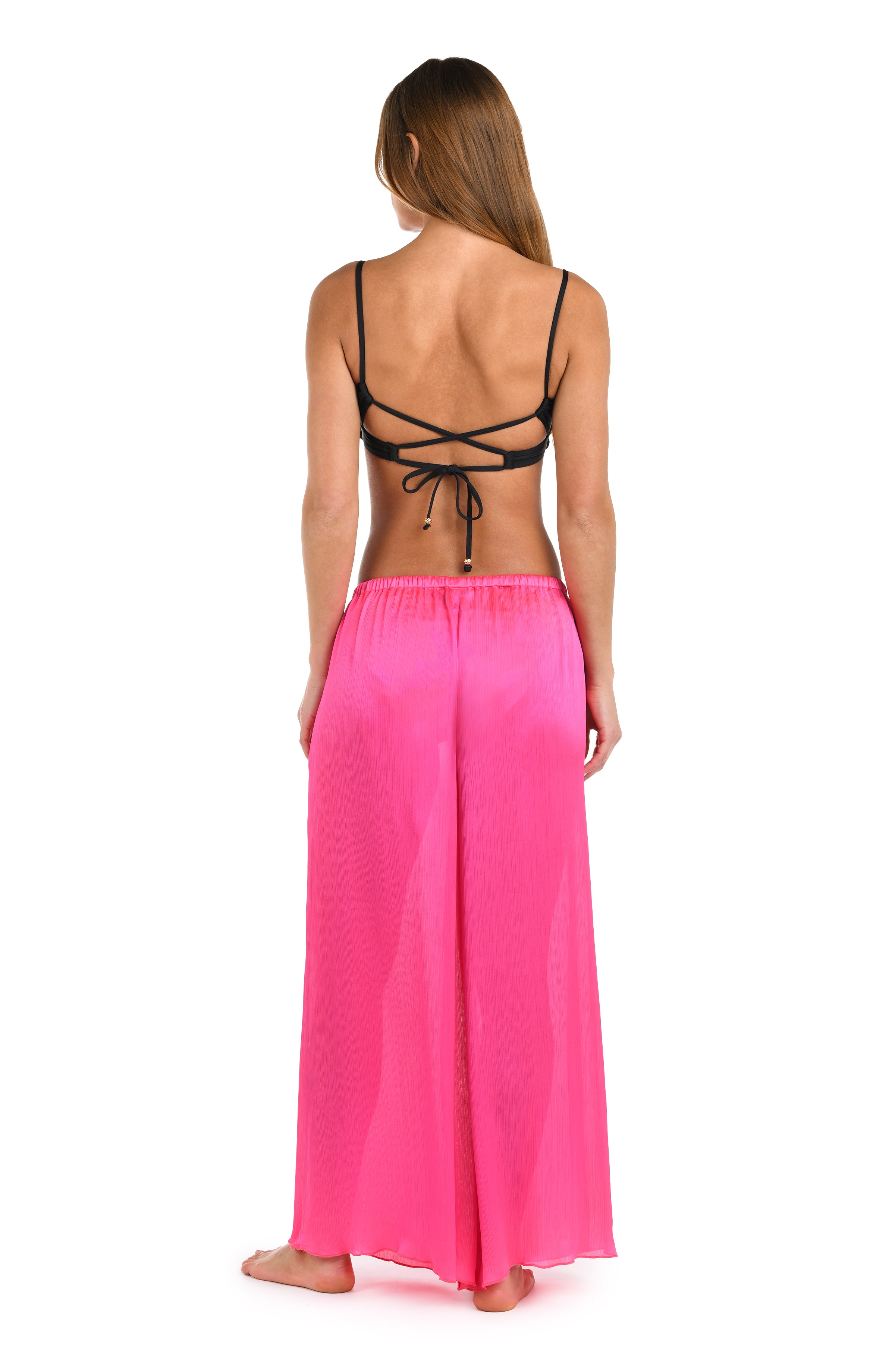 Full body back image of model wearing a solid bright pink crinkle pant cover up.       