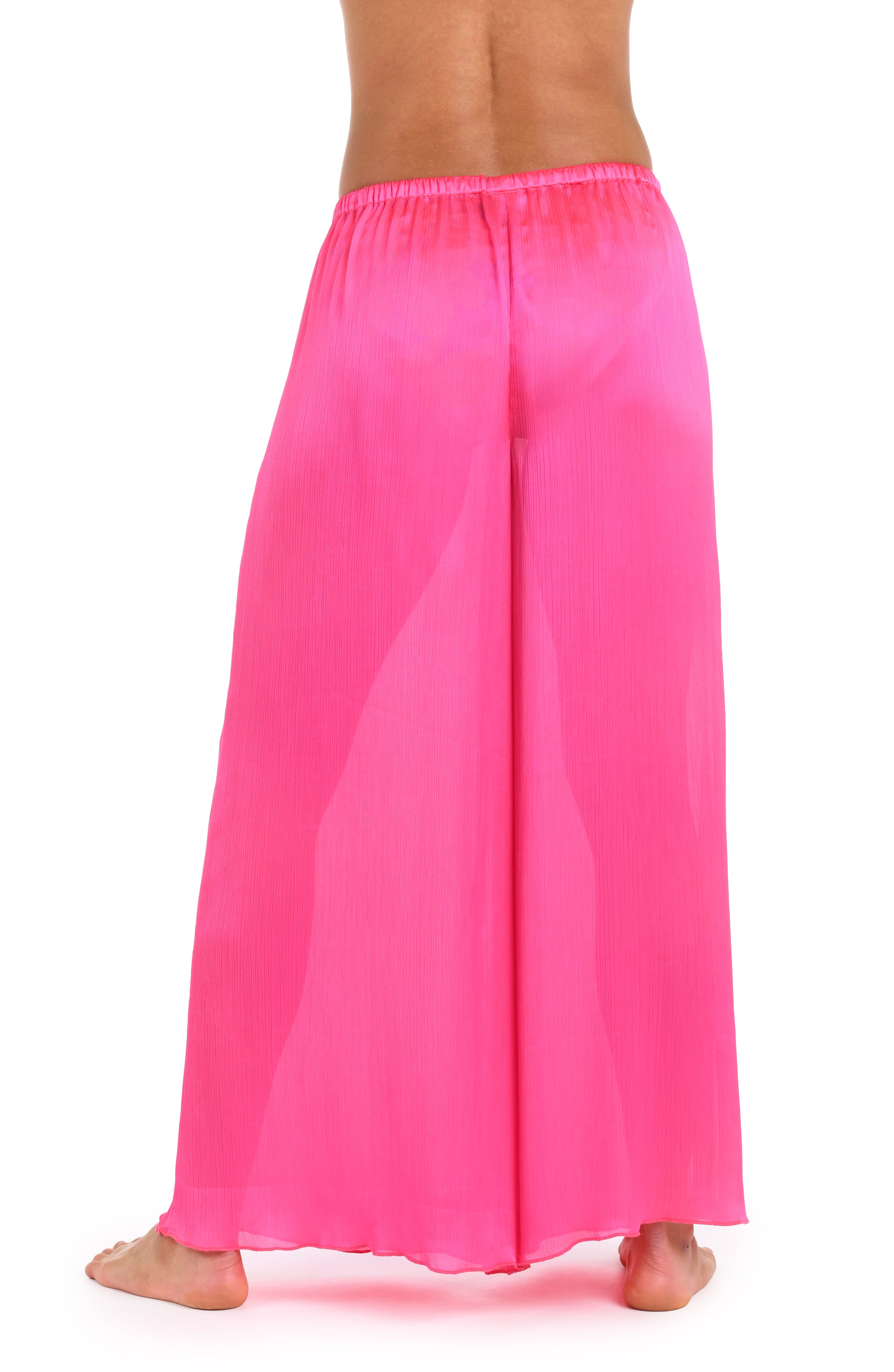 Back image of model wearing a solid bright pink crinkle pant cover up.       