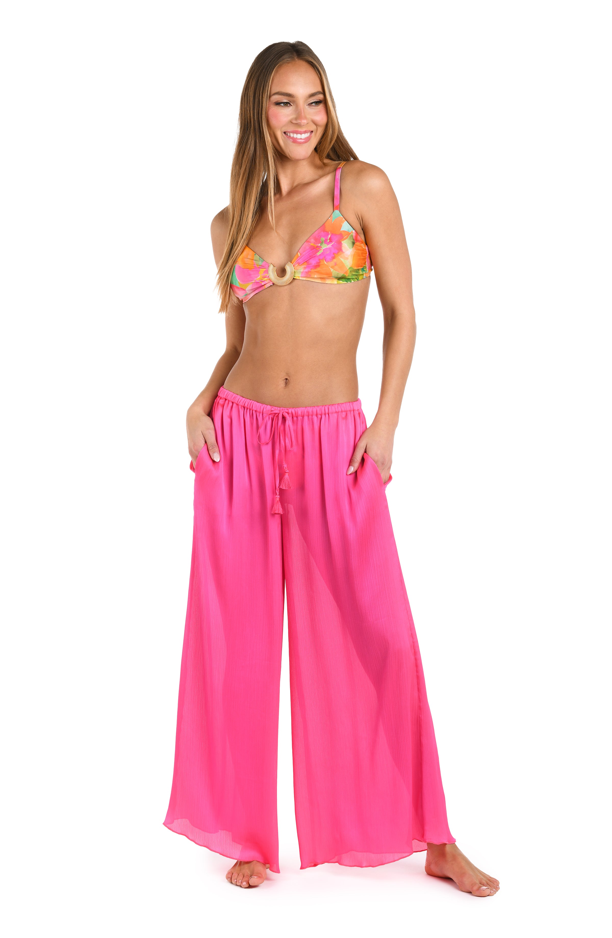 Full body front image of model wearing a solid bright pink crinkle pant cover up.       