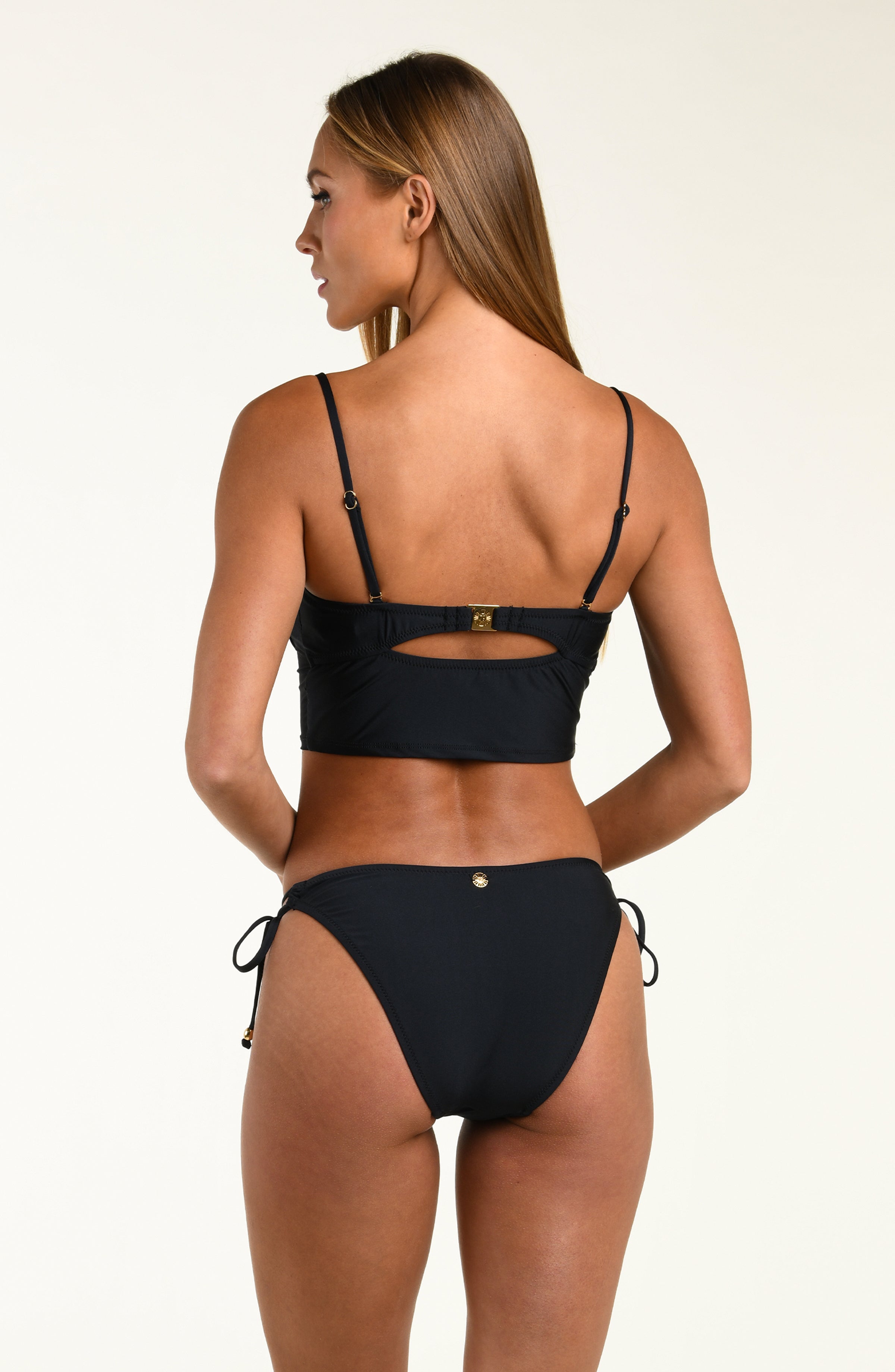 Woman wearing a black midkini top and matching bottom on a white background