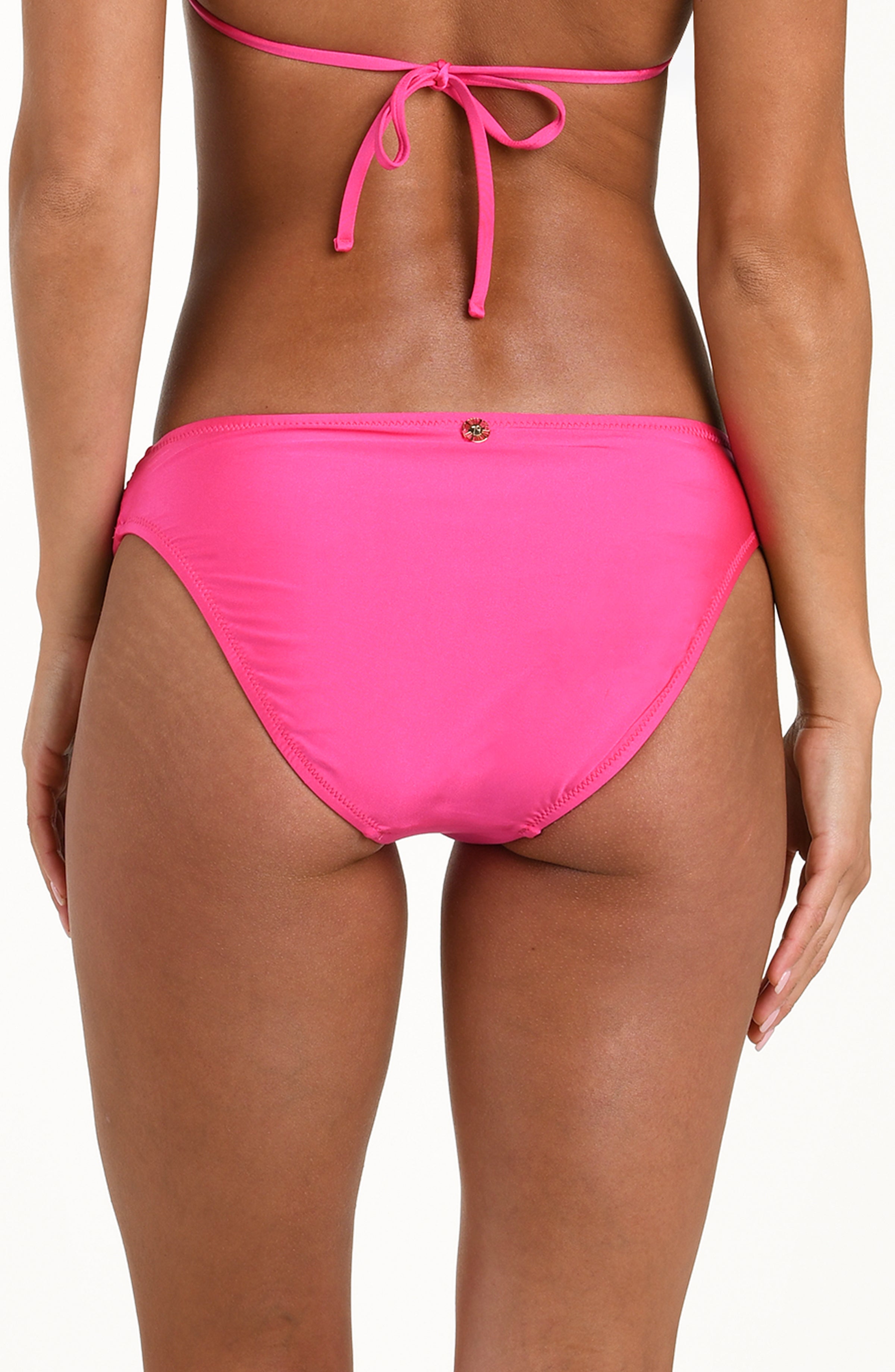 Back image of model wearing a solid black bikini bottom with a gold charm at center and moderate rear coverage.