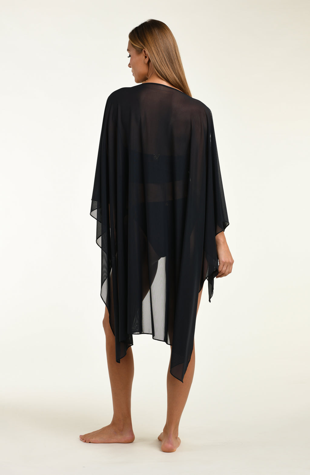 Woman wearing a black mesh tunic on a white background