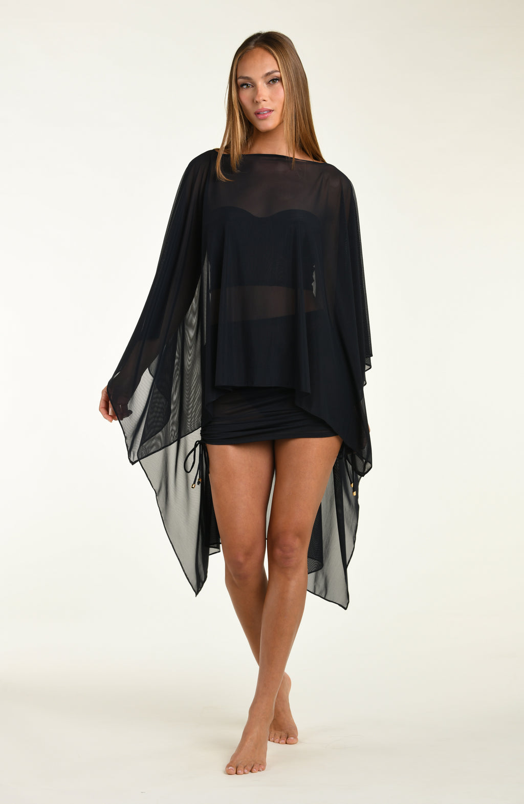 Woman wearing a black mesh tunic on a white background