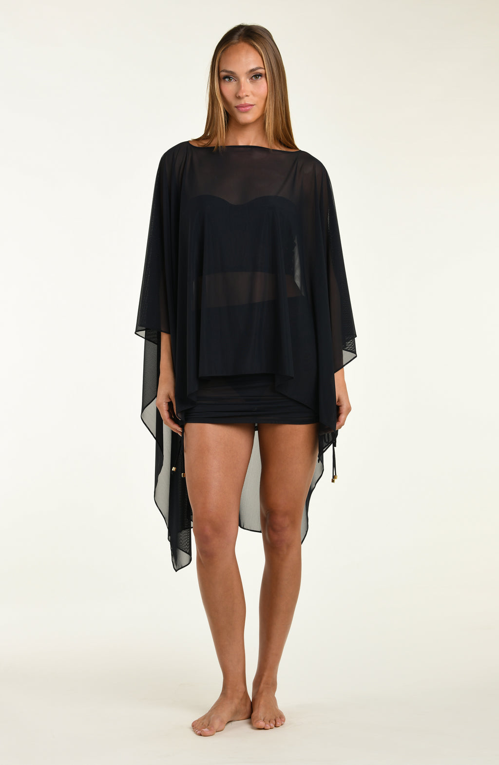 Woman wearing a black mesh tunic on a white background