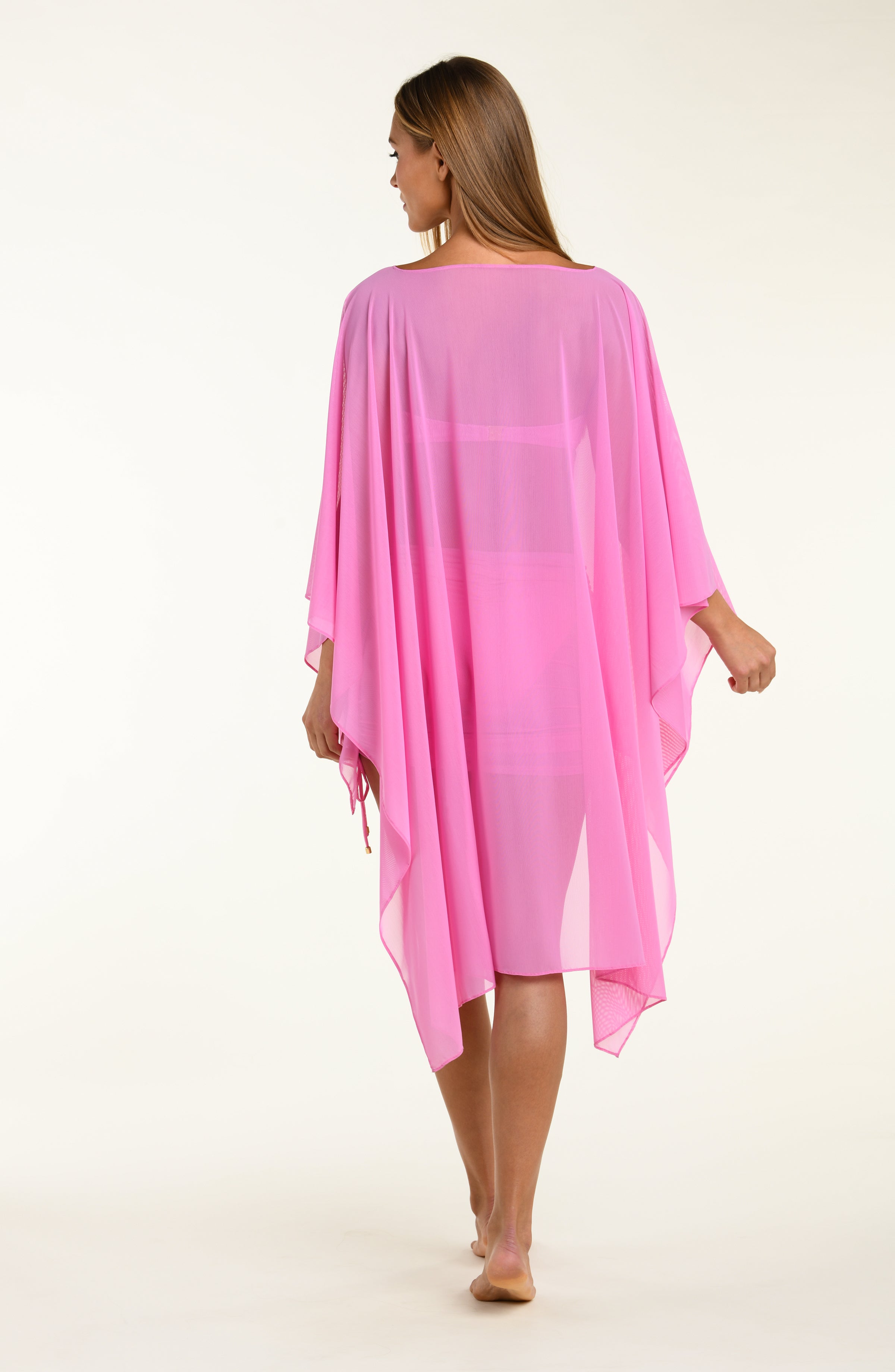 Woman wearing a pink tunic cover-up on a white background