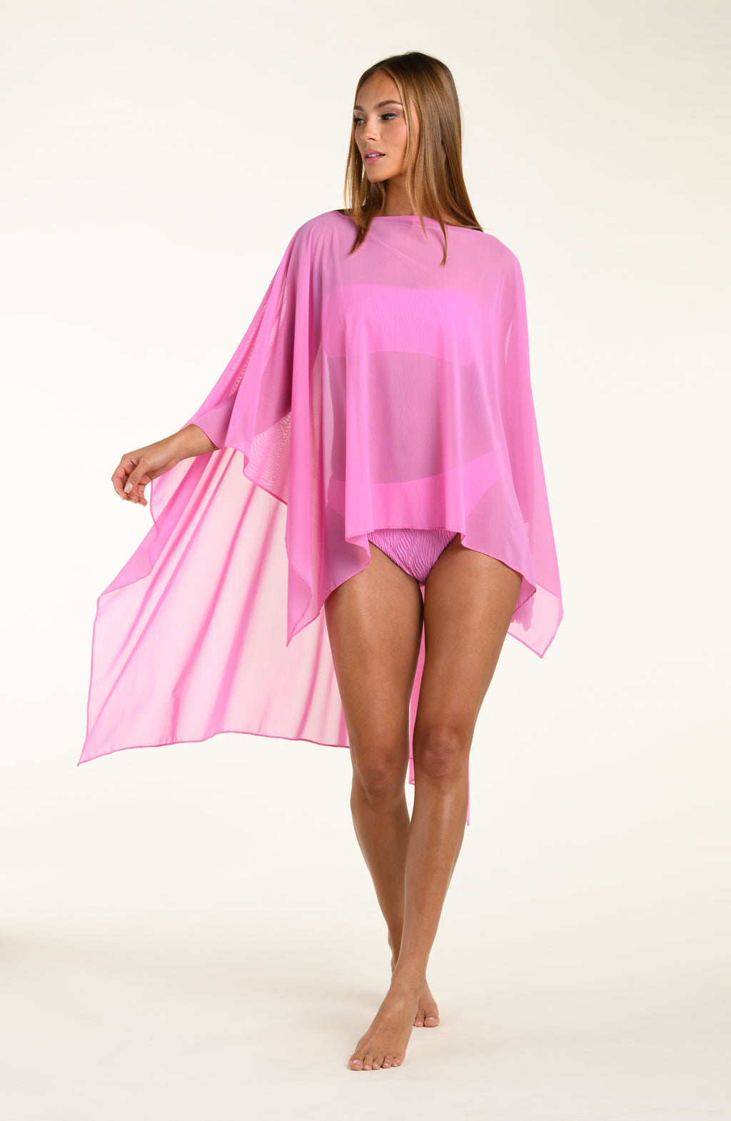 Woman wearing a pink tunic cover-up on a white background