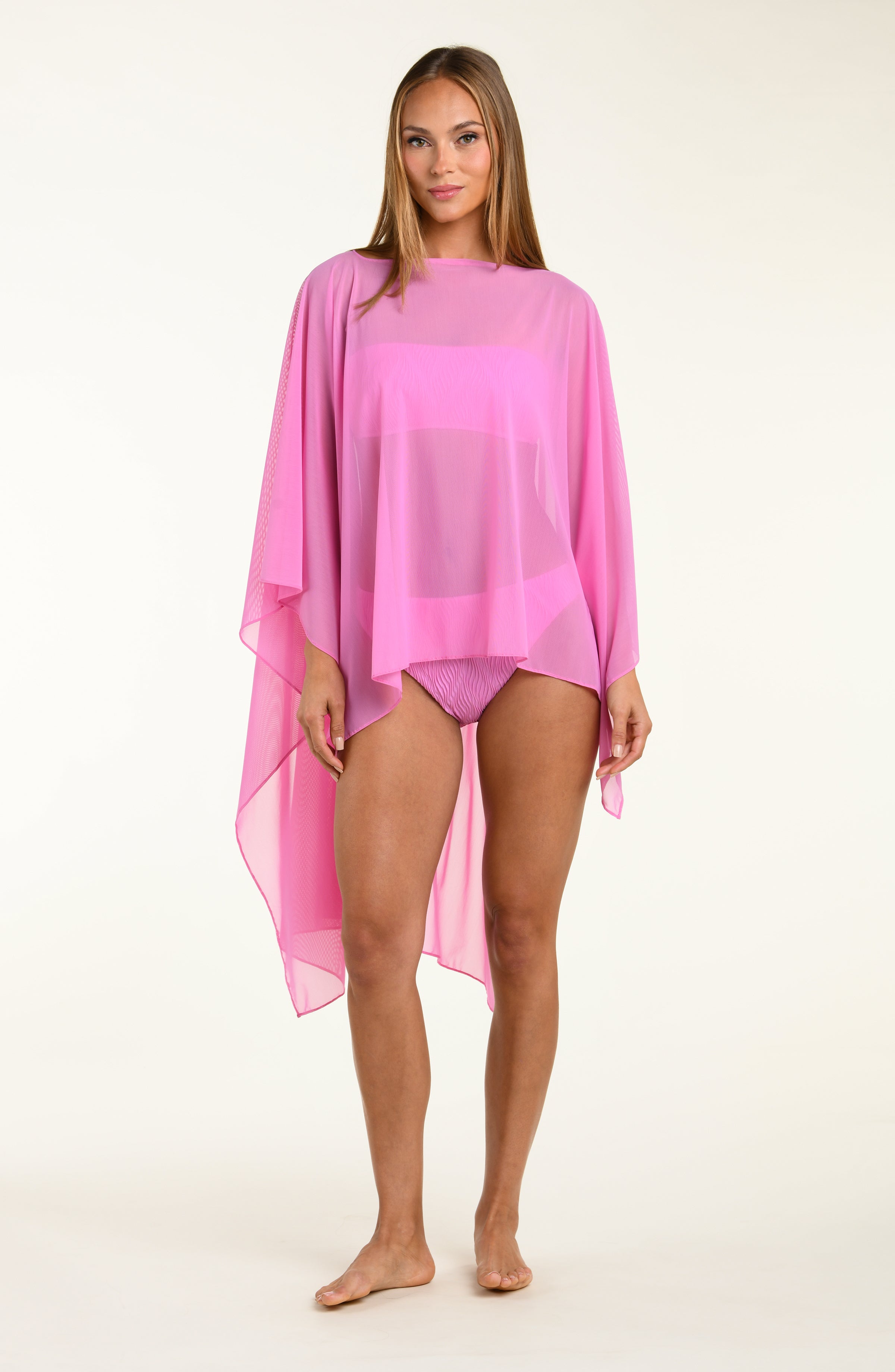 Woman wearing a pink tunic cover-up on a white background
