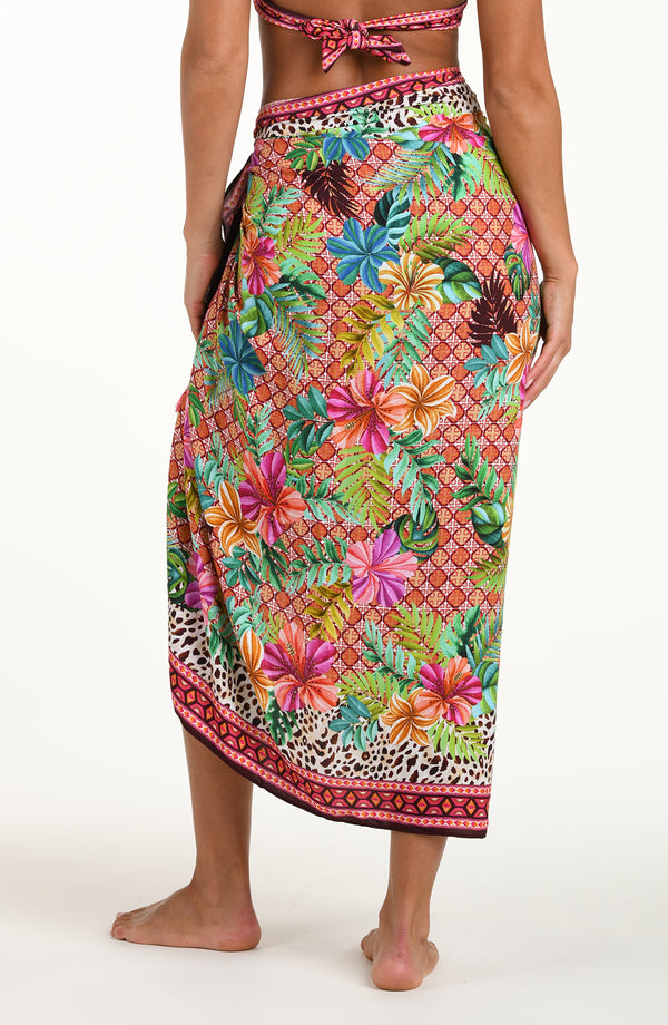 Back image of model wearing a multicolored tropical and leopard printed pareo wrap featuring a tie side. 