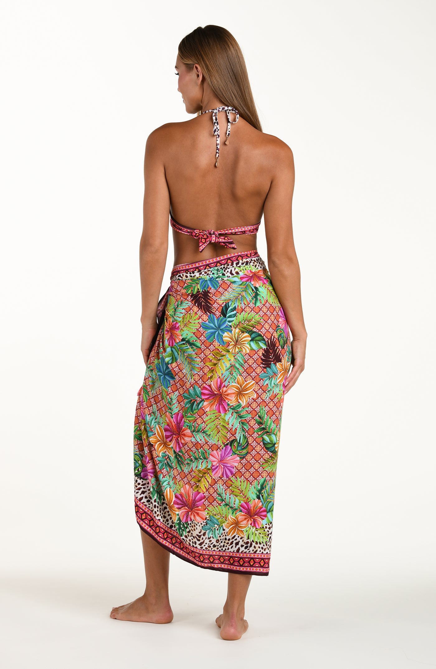 
                  
                    Full body back image of model wearing a multicolored tropical and leopard printed pareo wrap featuring a tie side. This is paired with a matching bikini top.
                  
                