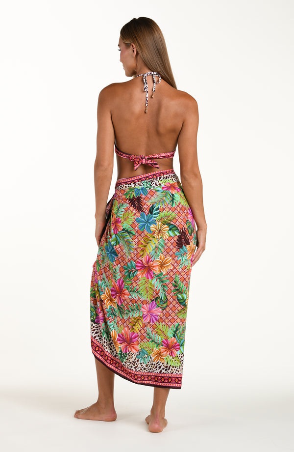 Full body back image of model wearing a multicolored tropical and leopard printed pareo wrap featuring a tie side. This is paired with a matching bikini top.